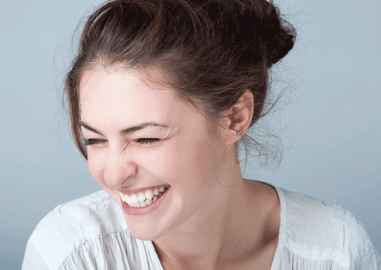 Woman showing off her newly improved smile.