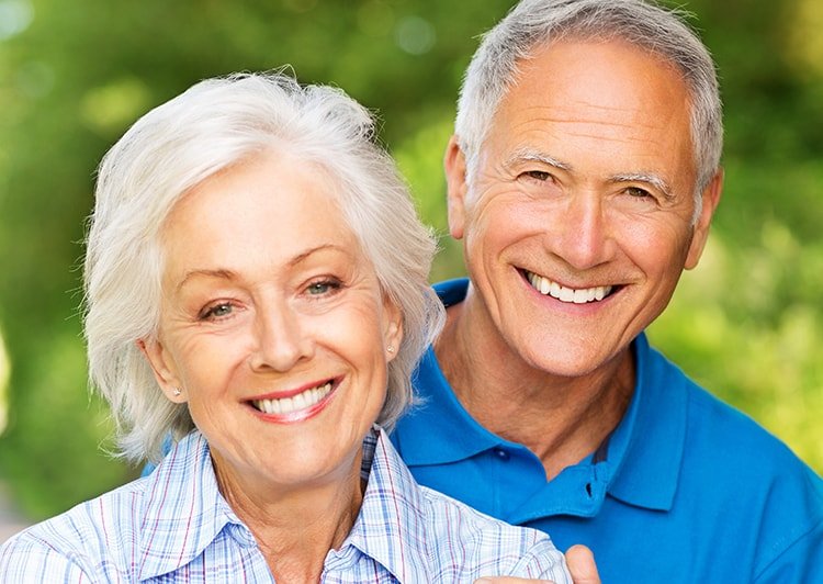 Dental Implants - Older couple smiling outside