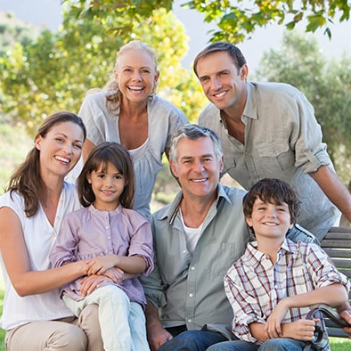 A multigenerational family posing for a family photo outside 