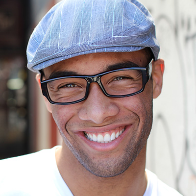 A young man with straight teeth smiling.