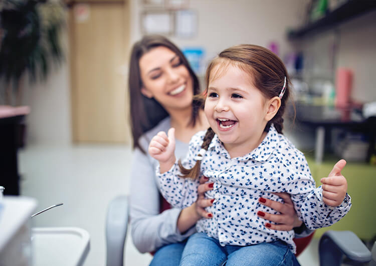 Mother and her child smiling during dental exam