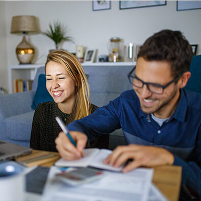 man and a woman sitting at a table filling out paperwork