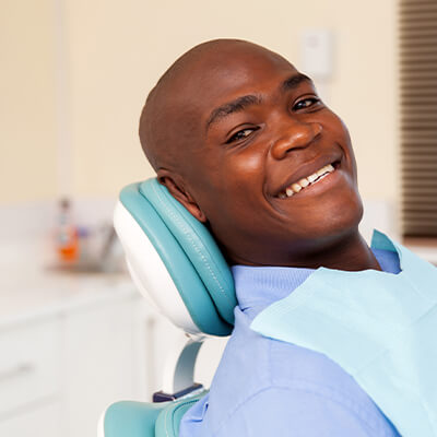 a man smiling as he sits in the dental chair