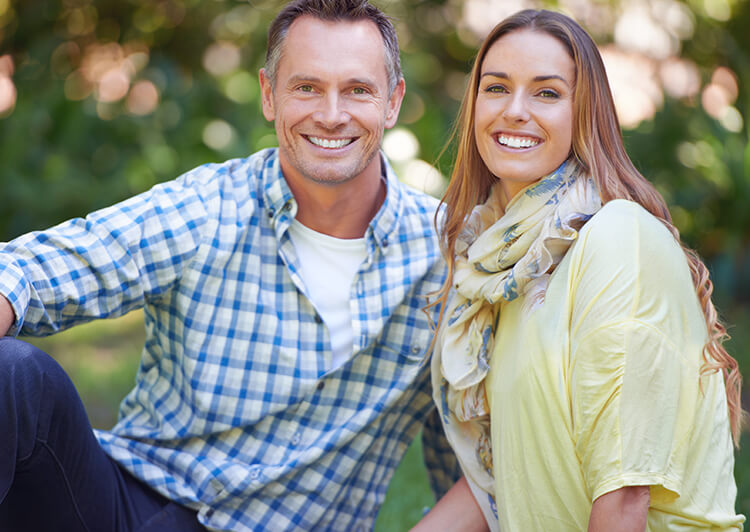 a man and woman smiling outdoors