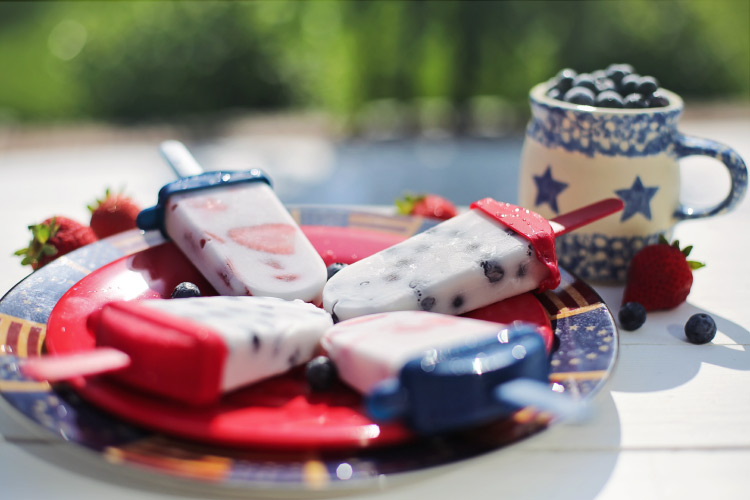 Homemade fruit popsicles on a red plate to celebrate the 4th of July in summer