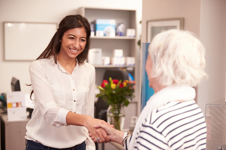 elderly patient being greeted at the dentist's front office