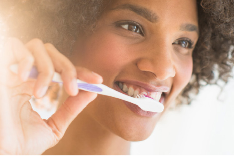 girl brushing her teeth to improve oral health in the new year