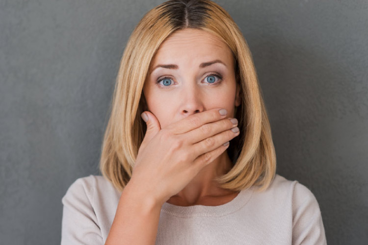 woman covers her mouth to hide her periodonal disease