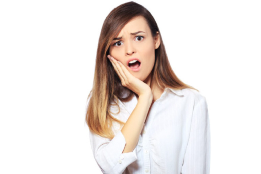 young woman holding her jaw in pain with an infected tooth