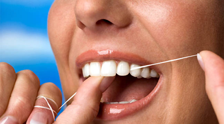 closeup of a woman flossing her teeth