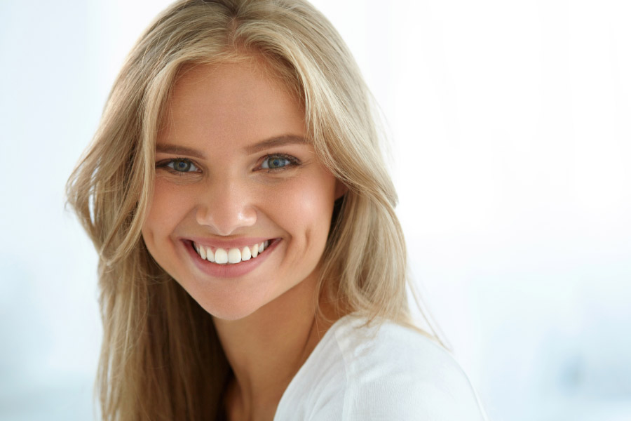 young woman smiles showing off her white smile