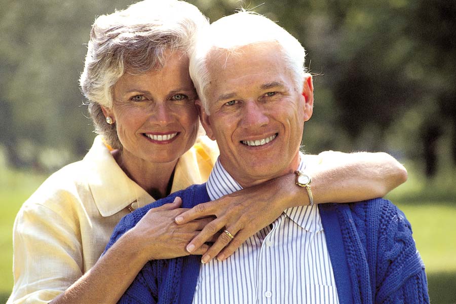 senior couple hug and smile after getting dental crowns
