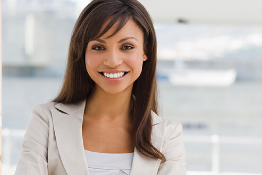 dark haired young woman smiles after getting a dental crown