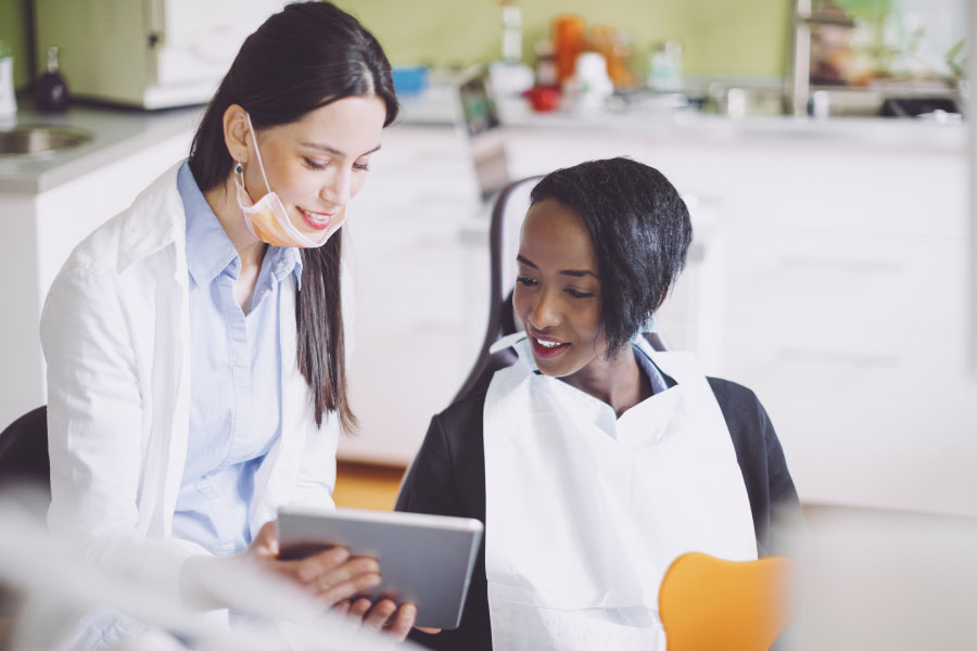 young woman consults the dentist on dental insurance benefits