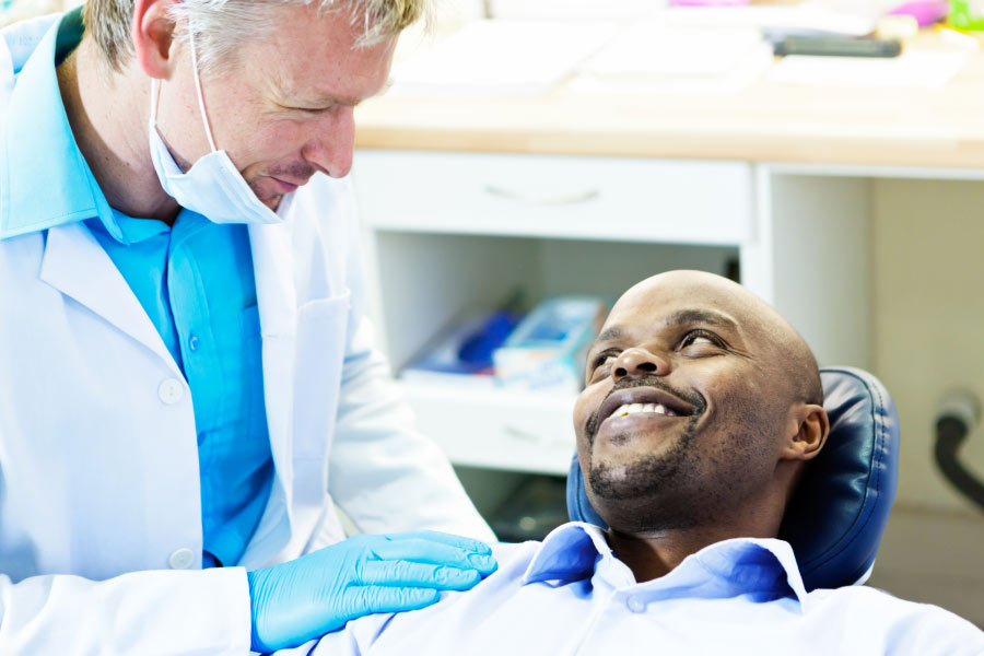 man in the dentist chair discusses dental implants with the dentist