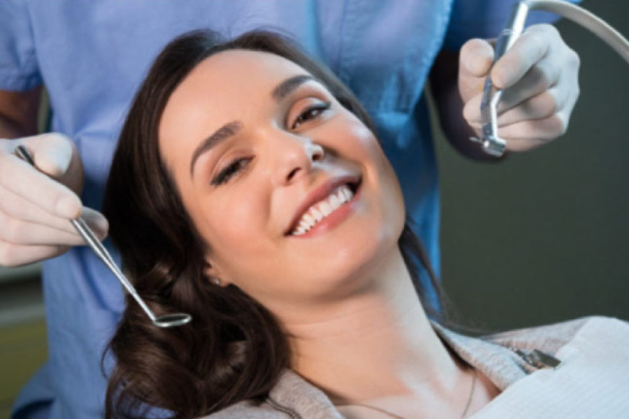young woman in the dentist chair for an exam and cleaning smiles showing off her white teeth